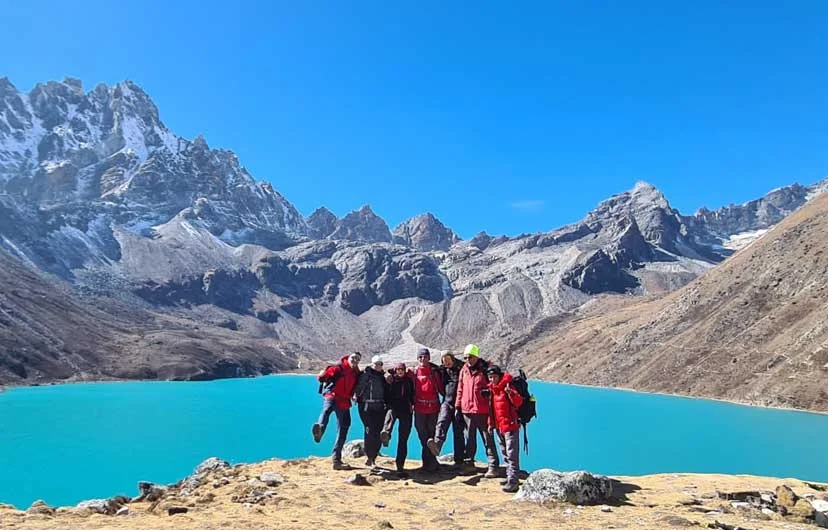 Trekkers enjoying the Gokyo Valley Trek with a scenic view of Gokyo Lake in the background.