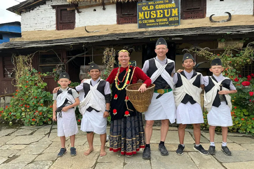 Family wearing traditional dress inside a museum in Ghandruk Village during the 5-day Ghorepani Poon Hill Trek in Nepal.