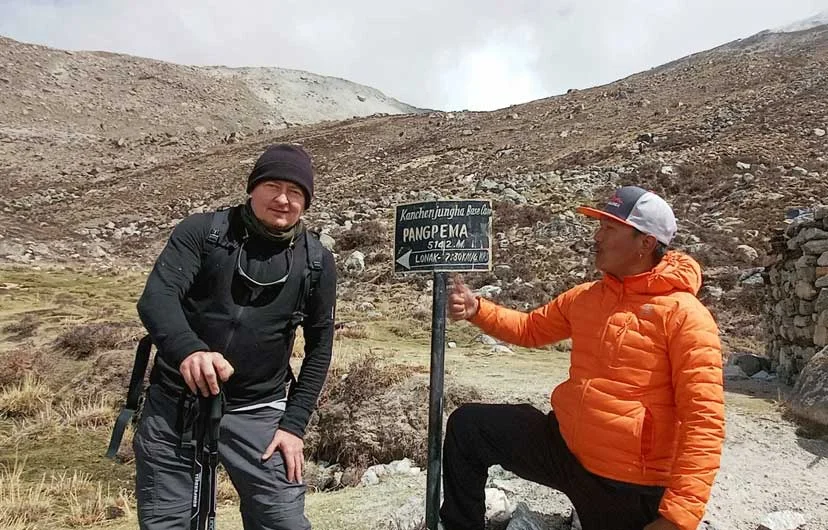 Trekkers at Pang Pema (Kanchenjunga North Base Camp) with stunning views of Kanchenjunga, the world's third-highest mountain, in eastern Nepal.