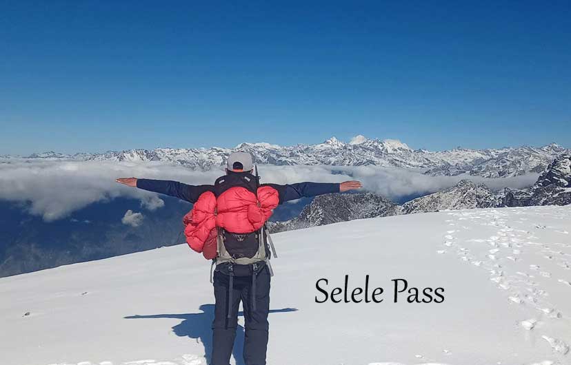 Trekkers crossing Sele La Pass during the Kanchenjunga Base Camp Trek, surrounded by rugged Himalayan landscapes and colorful prayer flags in eastern Nepal.